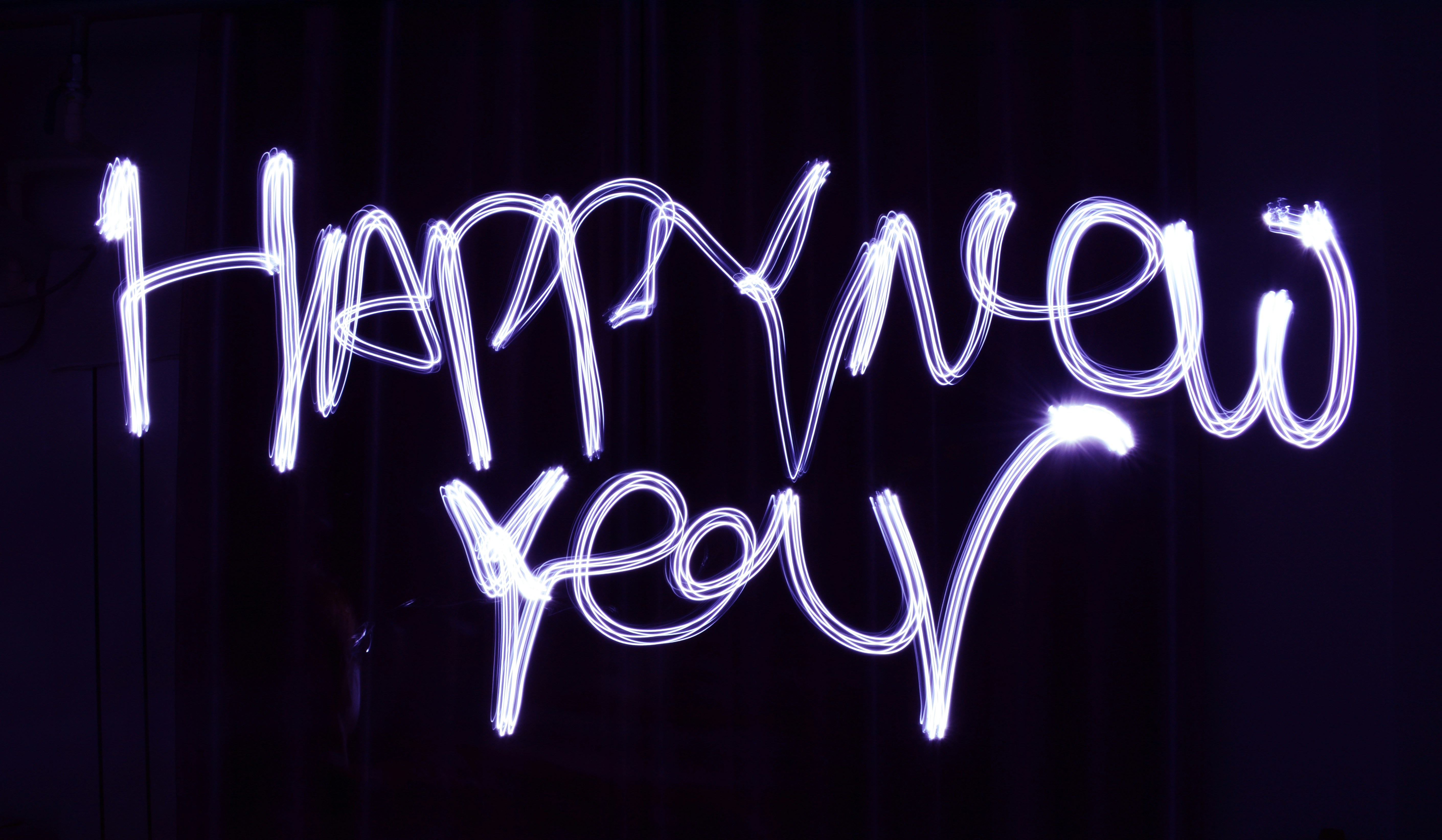 Happy New Year written in the air using a sparkler and long-exposure photograph